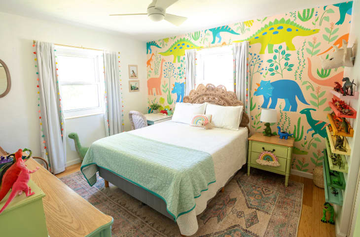   deti' bedroom with dinosaur theme. Dinosaur wallpaper in bright colors, shelves of rainbow toy dinosaurs