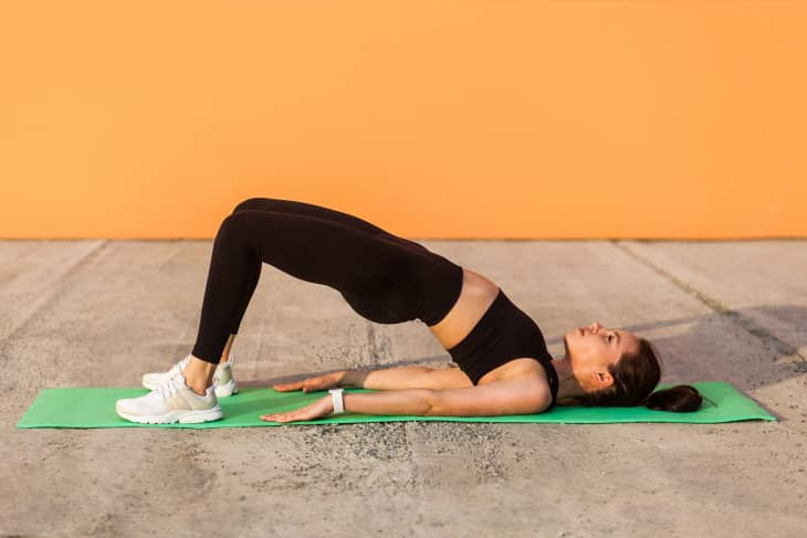   Dona practicant ioga, fent una postura de pont inclinada cap enrere