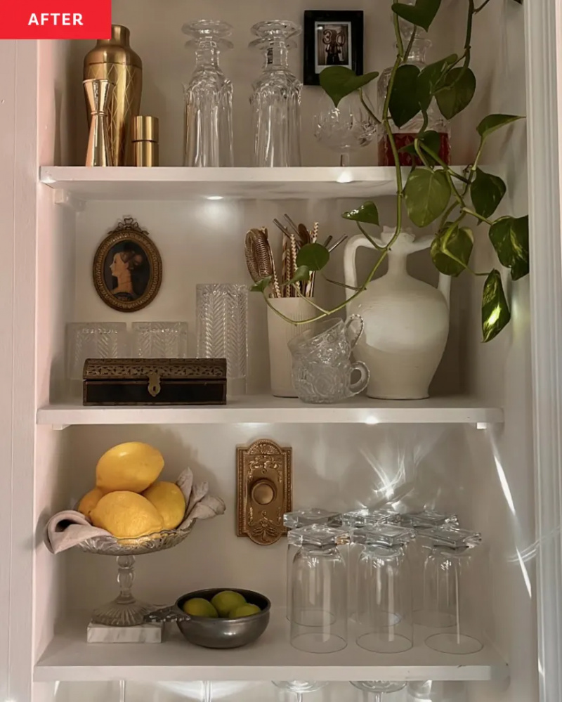   칼리 풀러's built-in looking kitchen nook shelves painted to match her light walls and styled with plants, dishes, and glassware