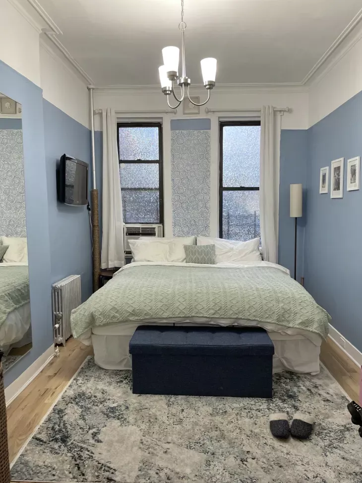   Плава спаваћа соба са великим креветом поред два прозора