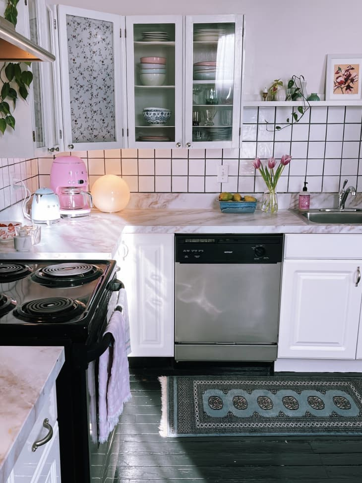   Kuchyňa s bielymi skrinkami a rastlinami na pulte