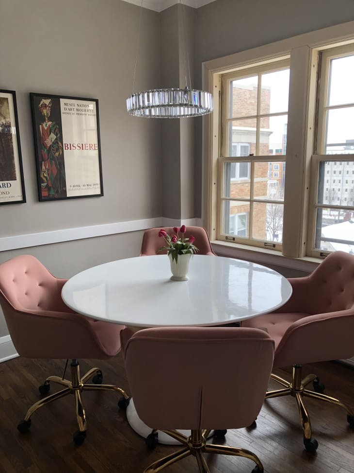   Okrúhly biely jedálenský stôl so štyrmi ružovými stoličkami